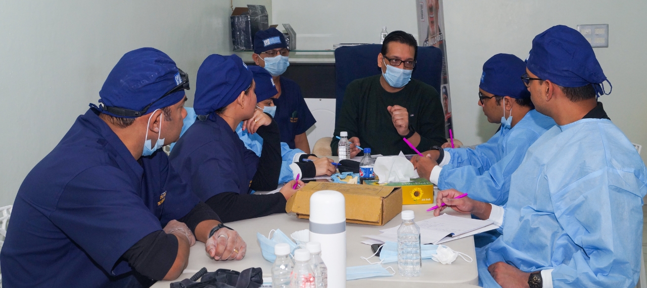 Students observing live implant surgery in clinic workshop
